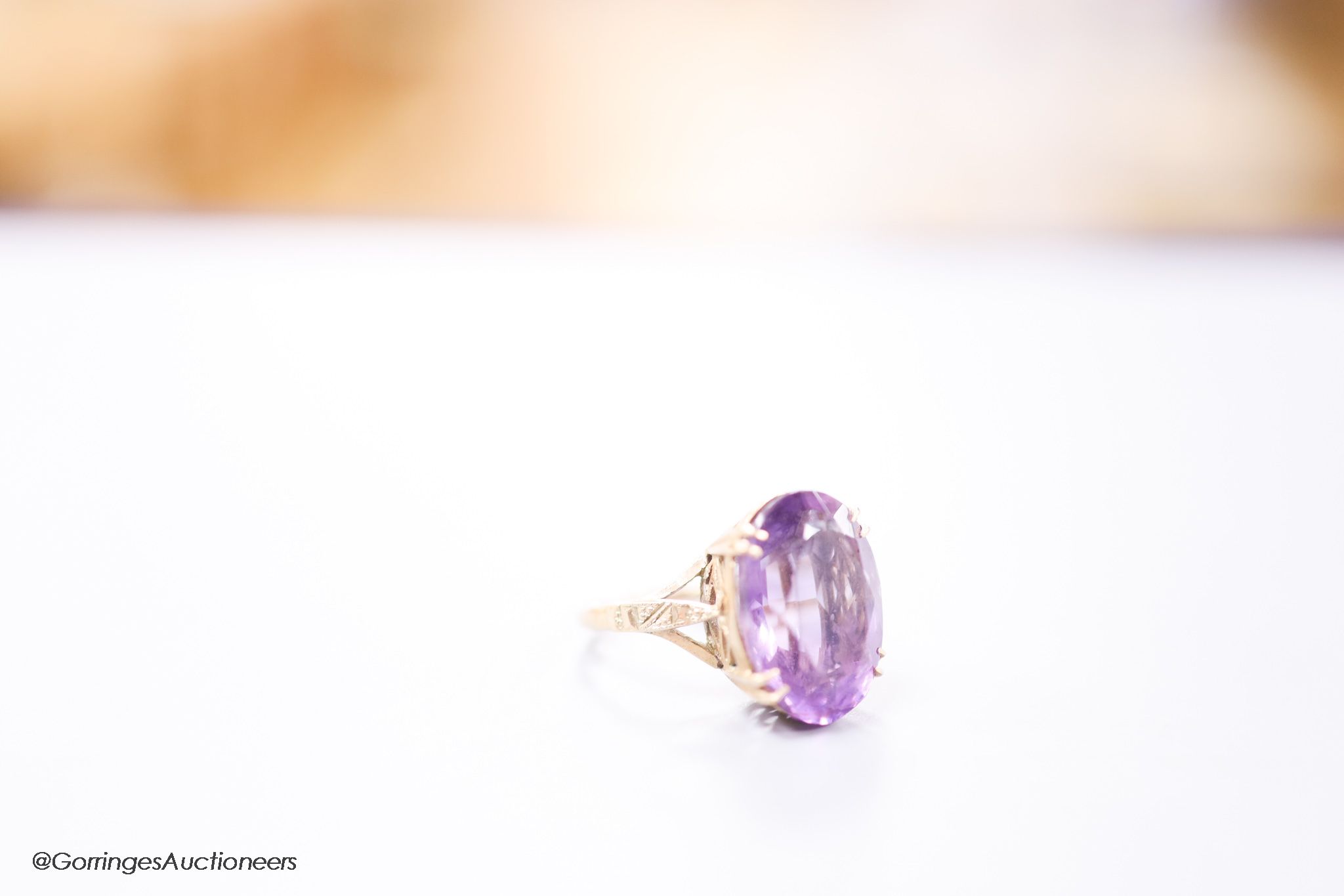 A 9ct gold and oval cut amethyst set dress ring, size H